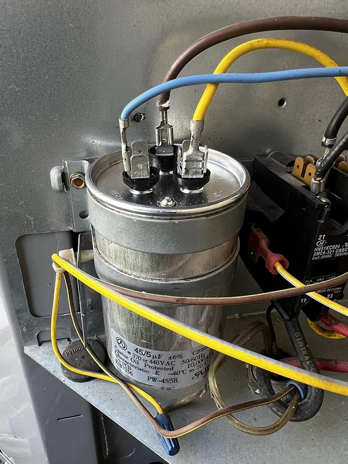Customer photo of AC capacitor showing physical damage and wear from heat exposure