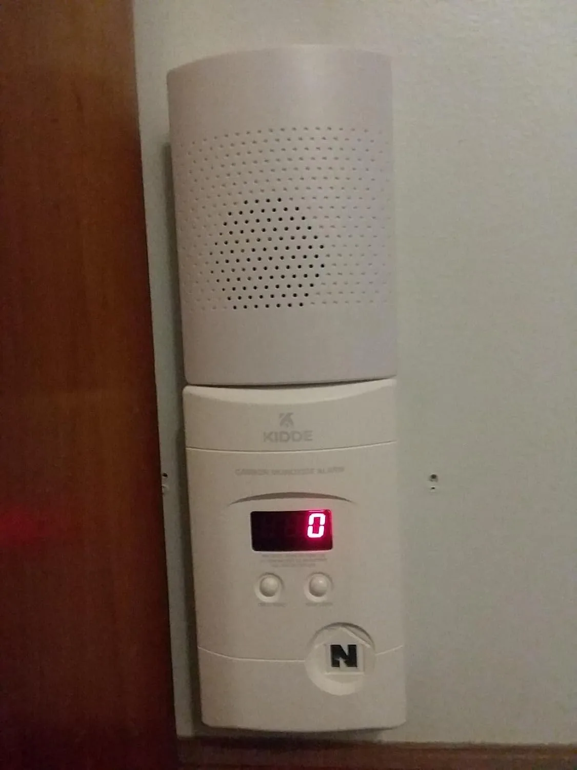 Customer photo showing CO detector mounted on bedroom wall near ceiling